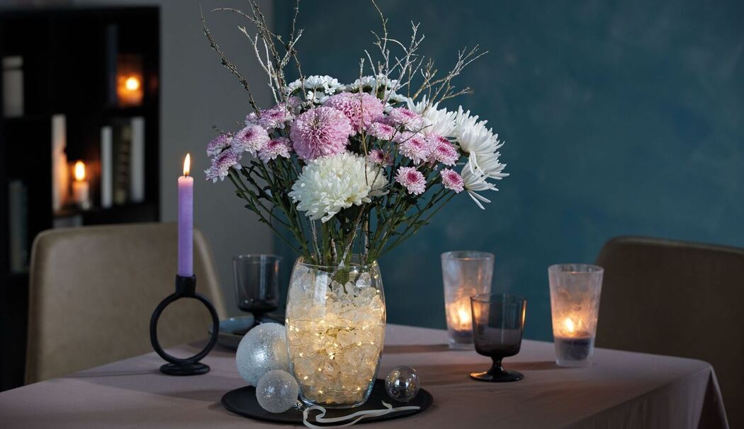 Winterliches Chrysanthemen-Arrangement auf einem Tisch Winterliches Chrysanthemen-Arrangement auf einem Tisch