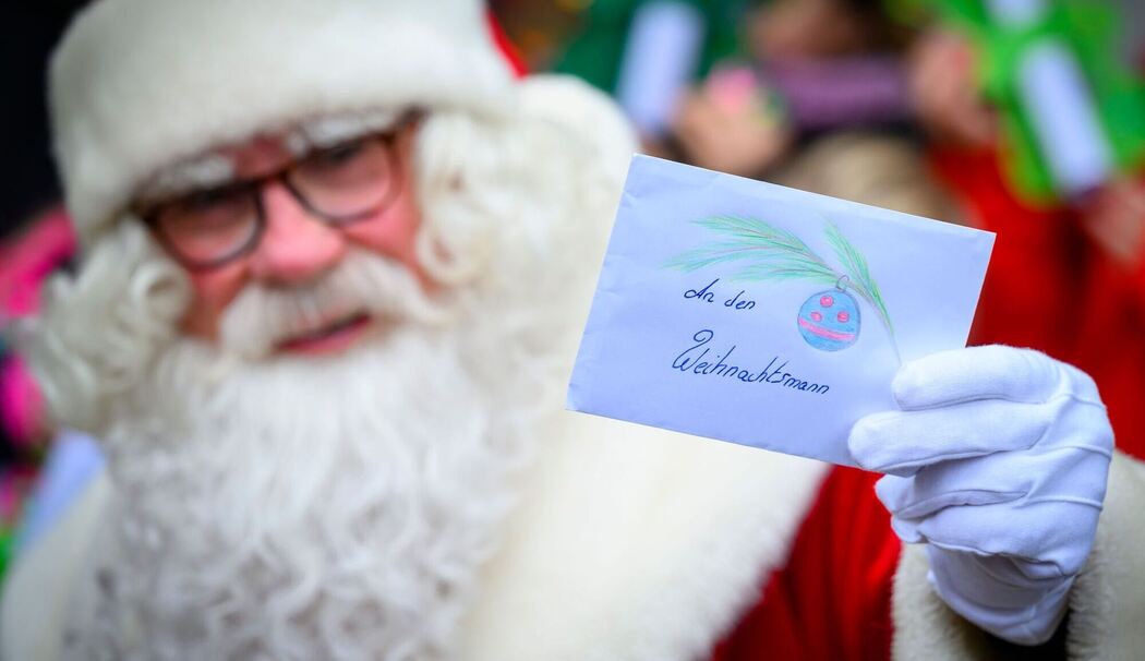 Weihnachtsmann hält Weihnachtspost hoch Weihnachtsmann hält Weihnachtspost hoch