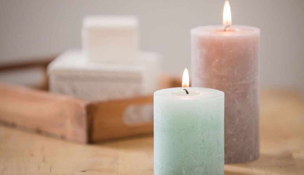 Blockkerzen brennen auf einer Kommode