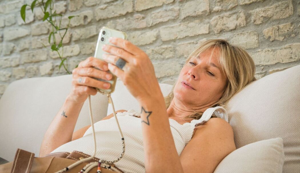 Frau mit Smartphone im Wohnzimmer Frau mit Smartphone im Wohnzimmer