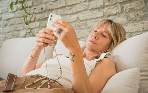 Frau mit Smartphone im Wohnzimmer