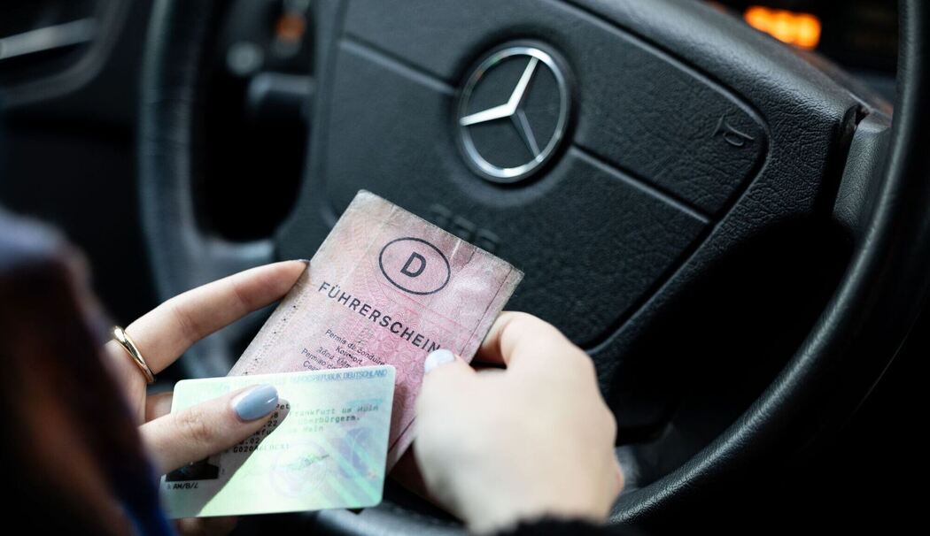 Eine Frau hält einen Papier-Führerschein und neuen Führerschein Eine Frau hält einen Papier-Führerschein und neuen Führerschein