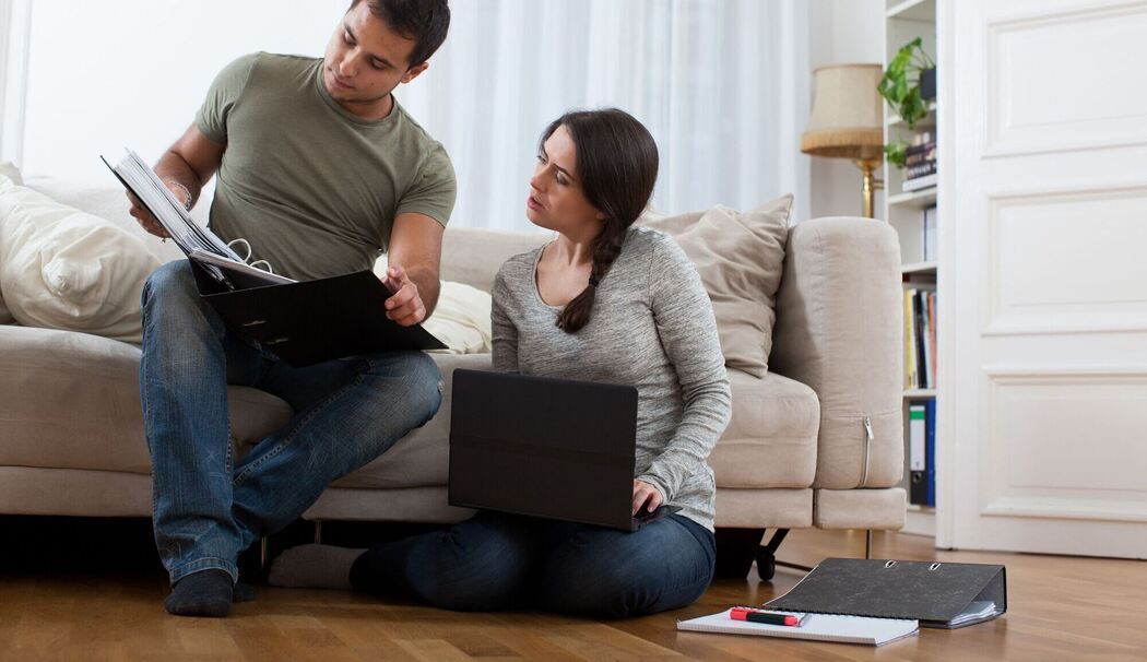 Ein Paar sieht gemeinsam in Unterlagen