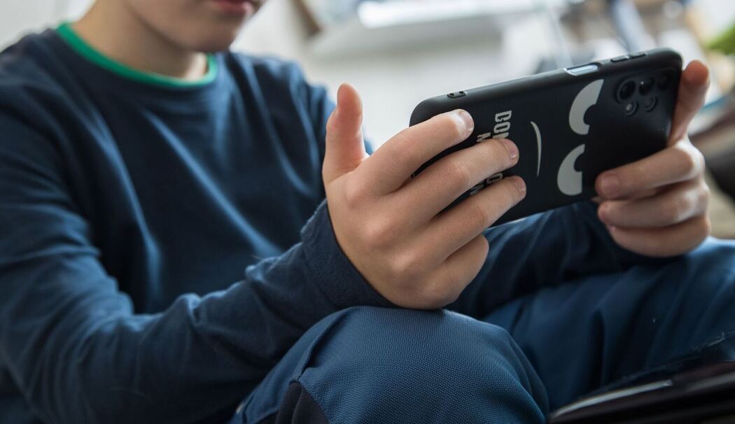 Junge schaut auf sein Smartphone