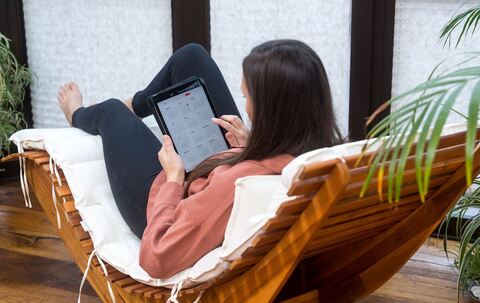 Eine Frau guckt auf einem Tablet auf einen Kalender