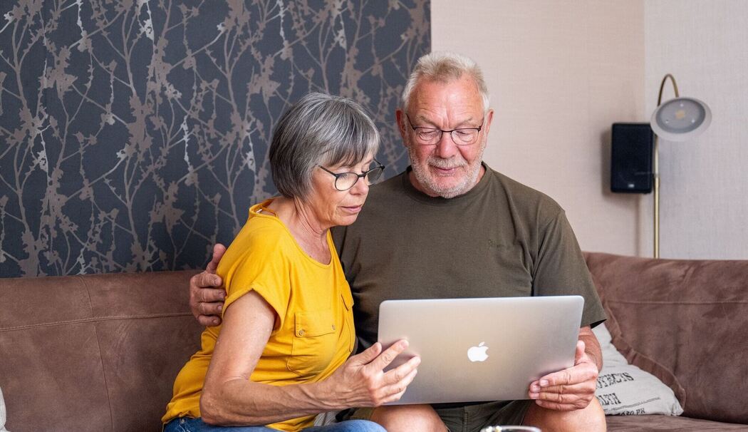 Ein Paar schaut auf einen Laptop