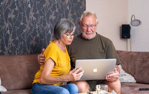 Ein Paar schaut auf einen Laptop