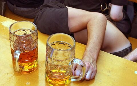 Ein Betrunkener sitz zusammengesunken in einem Bierzelt