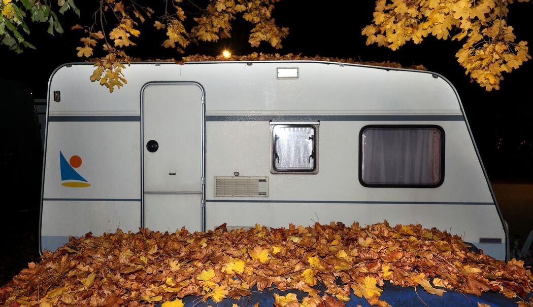 Ein Wohnwagen hinter Herbstlaub Ein Wohnwagen hinter Herbstlaub