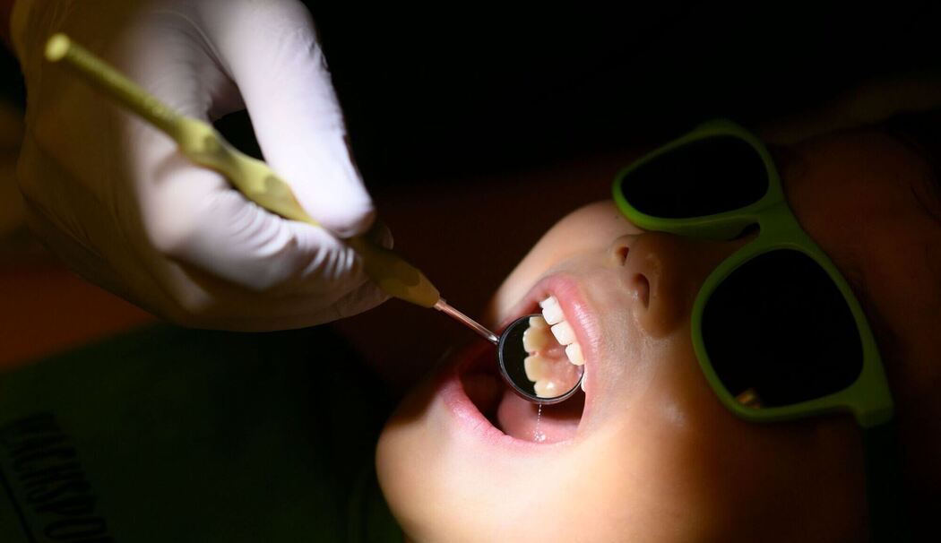 Eine Kinderzahnärztin untersucht ein dreijähriges Kind