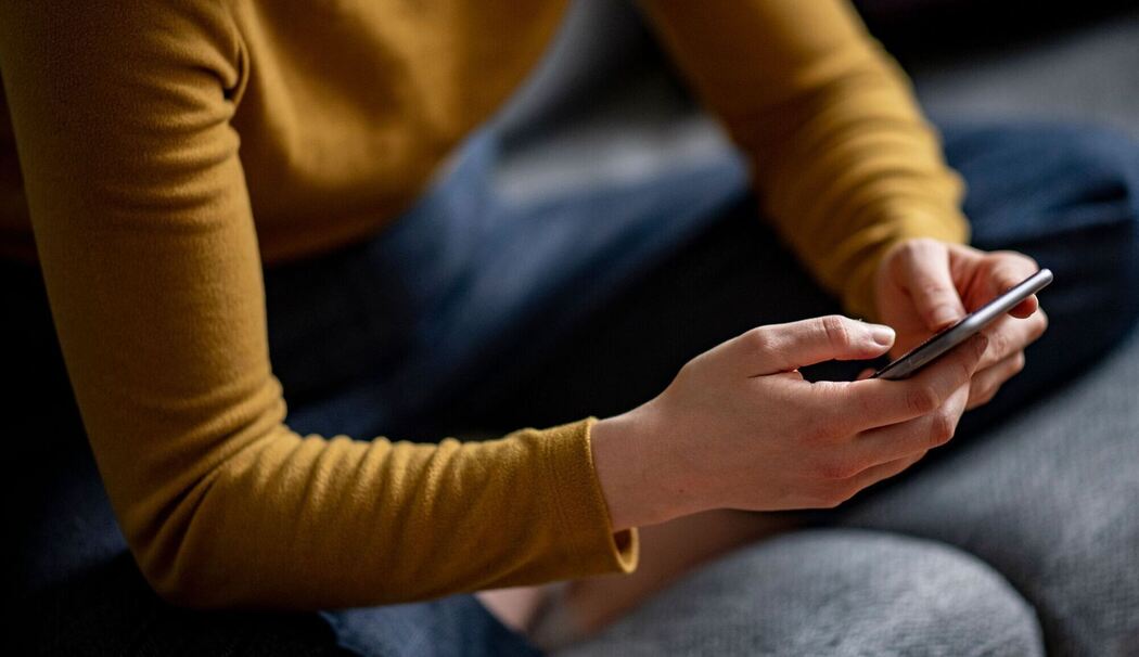Eine Frau hält ein Smartphone in den Händen