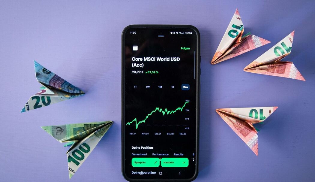 Geldscheinflieger zeigen auf einen ETF Kursverlauf