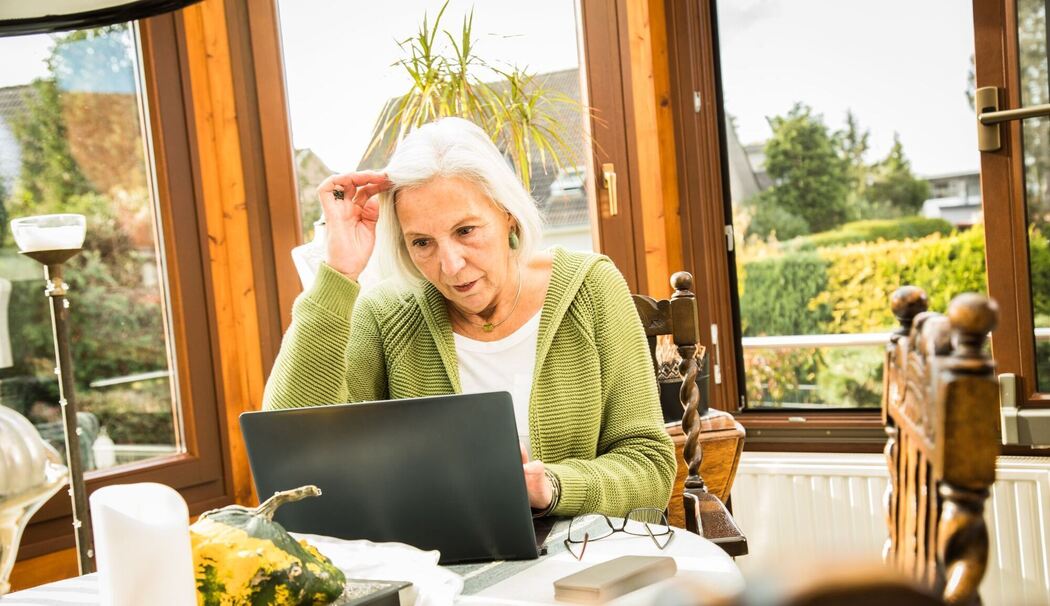 Eine Seniorin arbeitet an ihrem Laptop Eine Seniorin arbeitet an ihrem Laptop