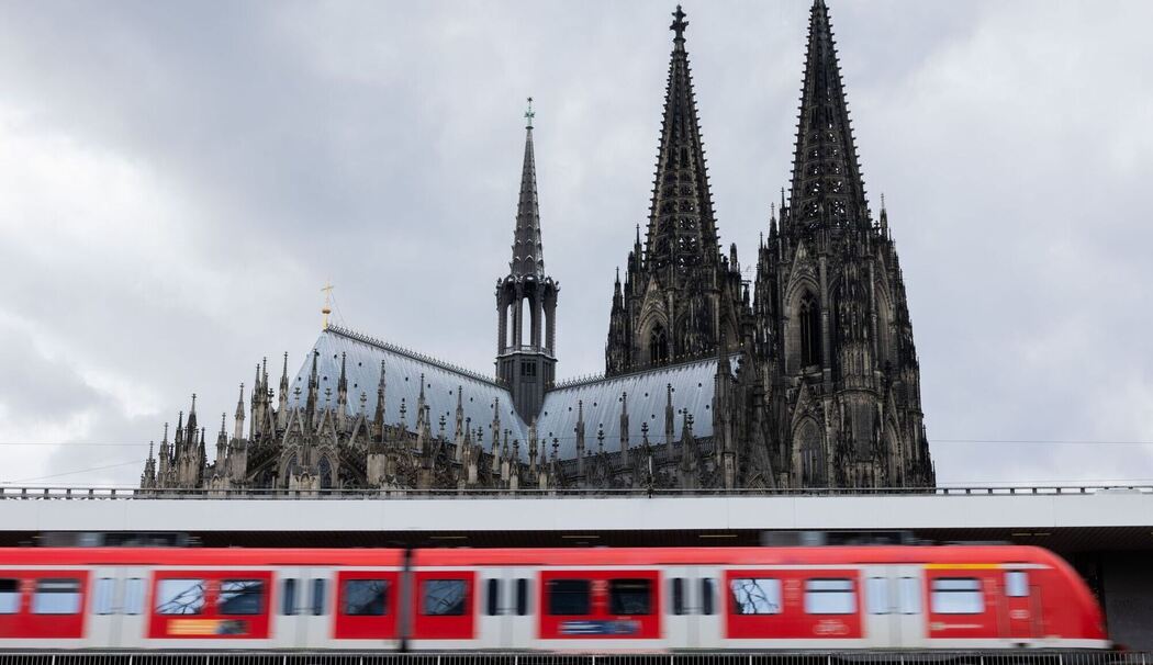 Regionalbahn fährt vor dem Kölner Dom in den Hauptbahnhof ein