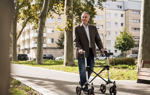 Senior läuft an einem Rollator