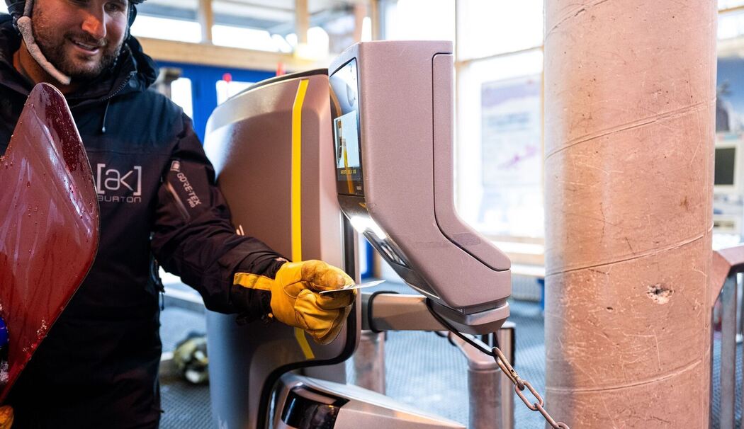 Ein Snowboarder scannt einen Skipass