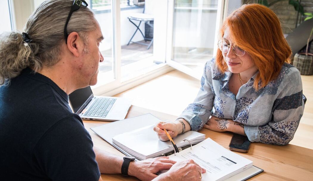 Frau und Mann sitzen vor Unterlagen Frau und Mann sitzen vor Unterlagen
