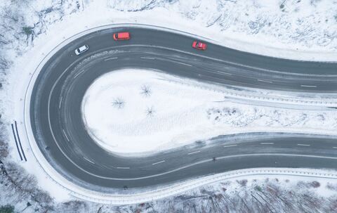 Autos fahren bei winterlichem Wetter eine Serpentine entlang