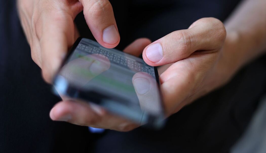 Mann tippt auf einem Smartphone eine WhatsApp Nachricht