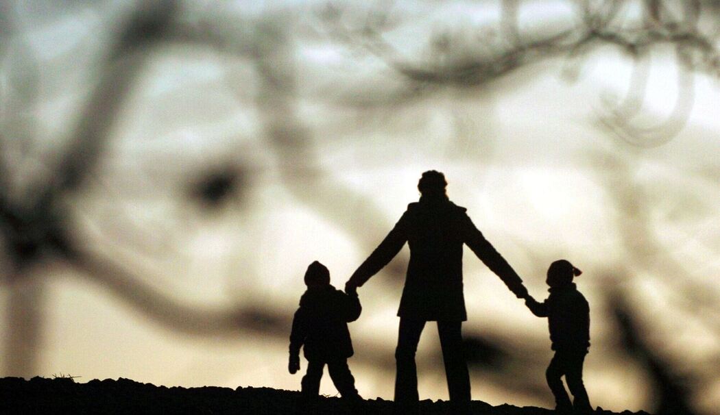 Eine Frau geht mit ihren Kindern spazieren