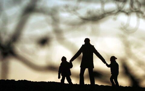 Eine Frau geht mit ihren Kindern spazieren