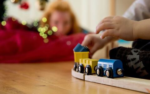 Ein Kind spielt mit einer Holzeisenbahn