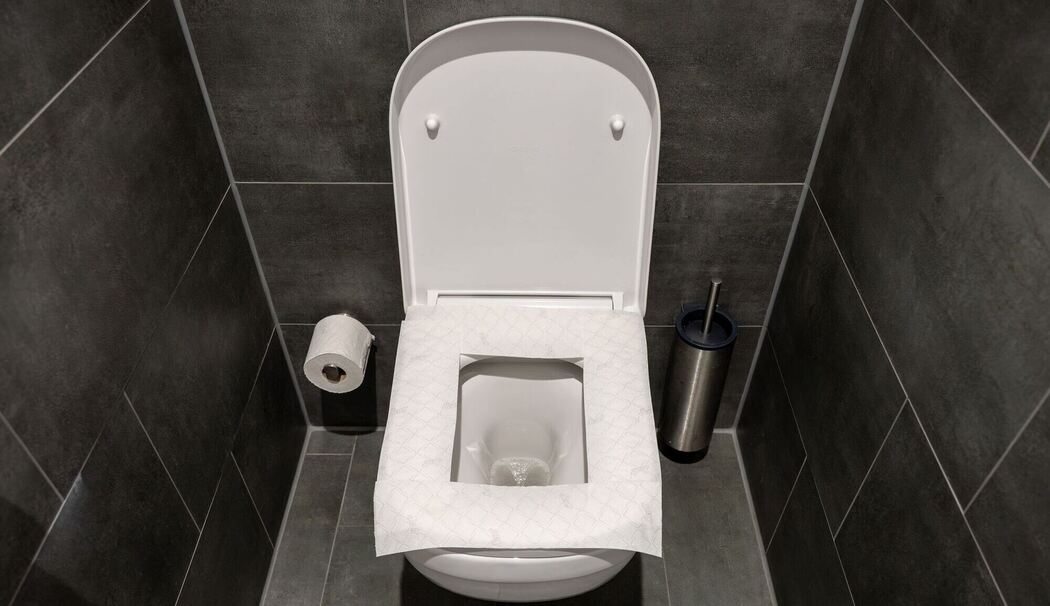 Ein Toilettensitz ist mit Toilettenpapier belegt