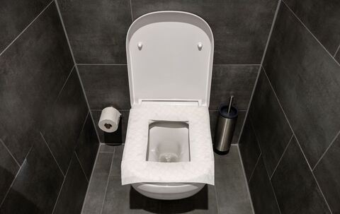 Ein Toilettensitz ist mit Toilettenpapier belegt