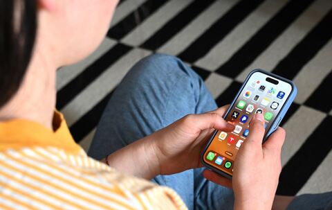 Eine Jugendliche sitzt am Smartphone (Archivbild)