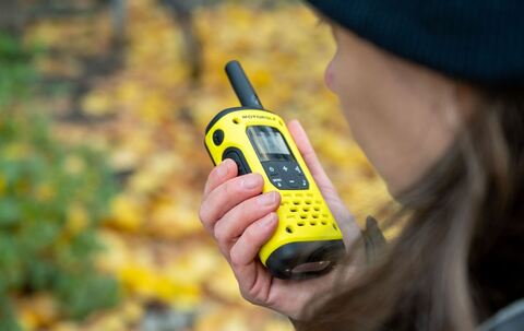 Eine Frau spricht in ein Walkie-Talkie in ihrer Hand