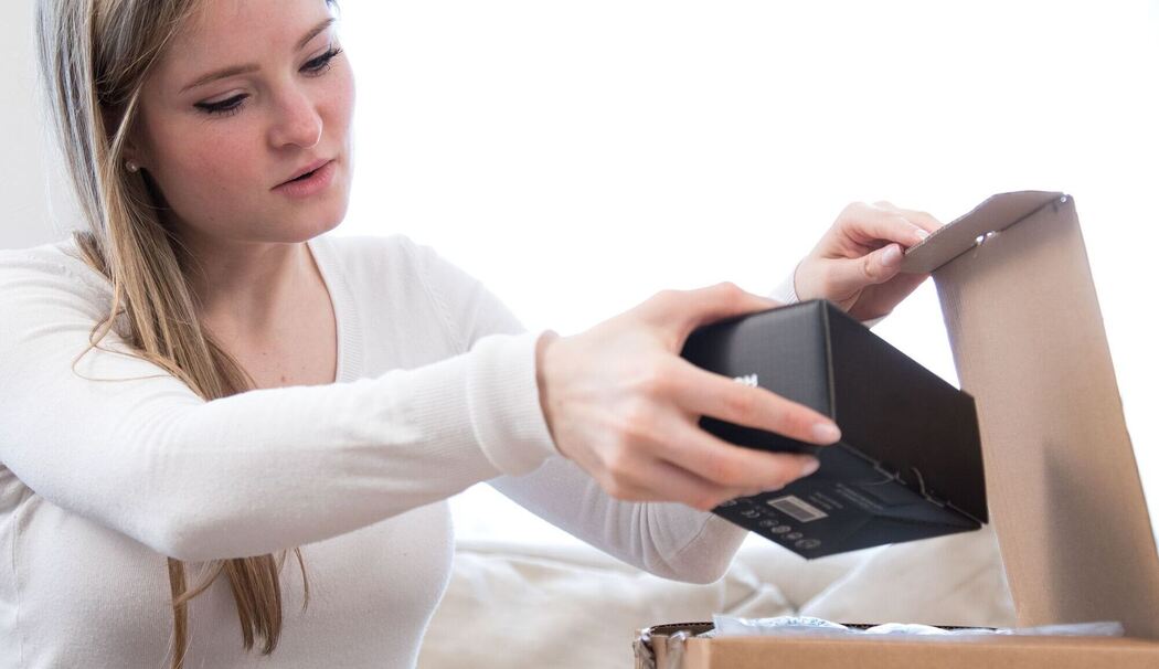 Eine Frau öffnet ein Paket