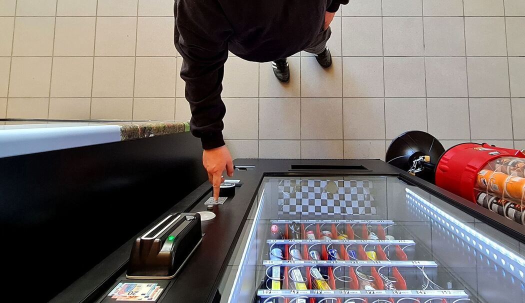 GEin Mann kauft etwas aus dem Automaten