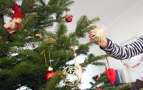 Mädchen schmückt einen Weihnachtsbaum