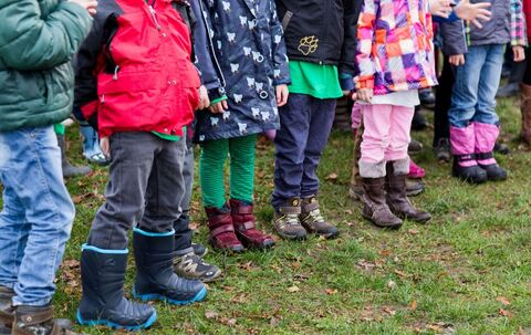 Kinder stehen in einem Garten