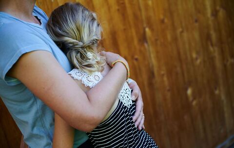 Ein Mädchen wird in den Arm genommen und getröstet