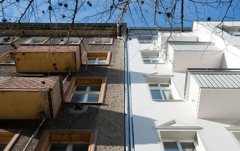 Ein unsaniertes Mehrfamilienhaus neben einem sanierten Haus