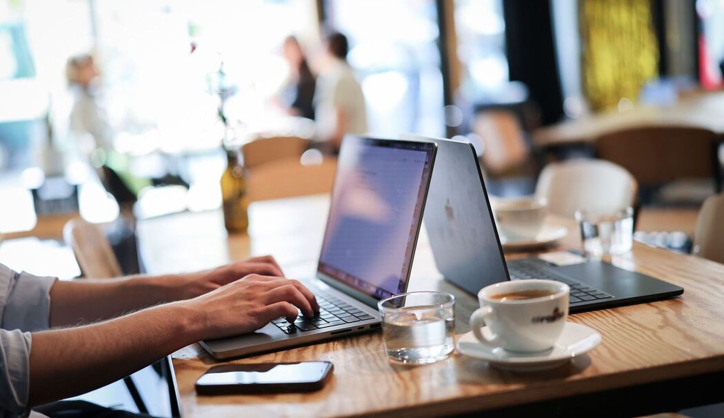 Ein Mensch arbeitet an seinem Computer in einem Café