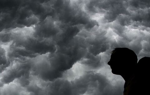 Ein Mann steht unter einem stürmischen Himmel