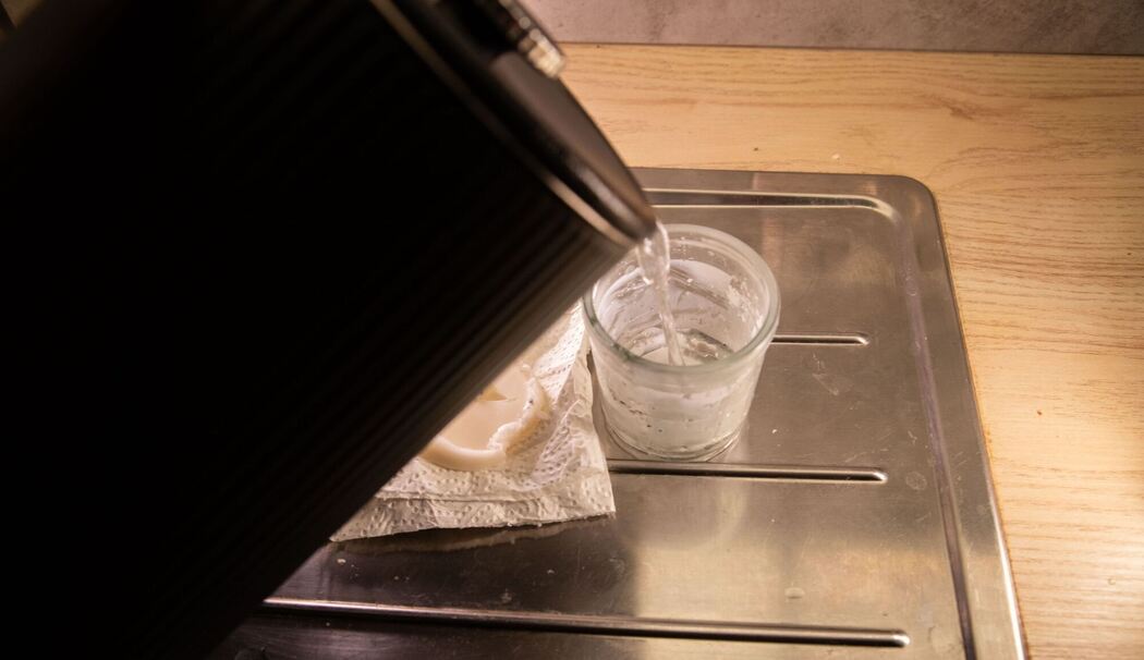 Heißes Wasser in das Dekoglas mit Wachsresten gegossen Heißes Wasser in das Dekoglas mit Wachsresten gegossen