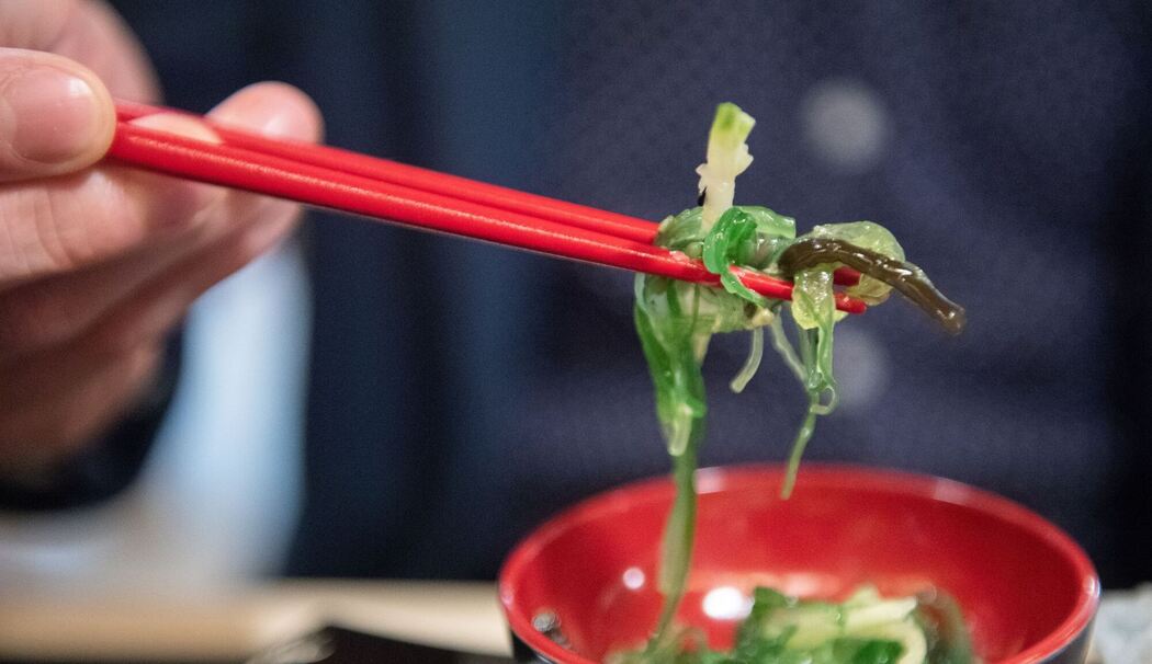 Ein Mann isst einen Wakame-Algensalat