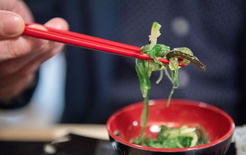 Ein Mann isst einen Wakame-Algensalat