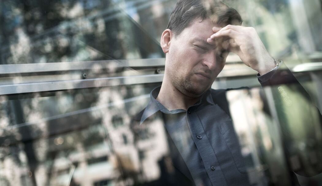 Gestresster Mann greift sich an die Stirn