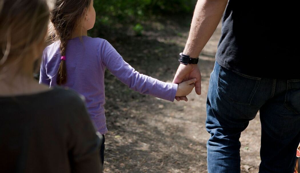 Ein Vater geht Hand in Hand mit seiner Tochter