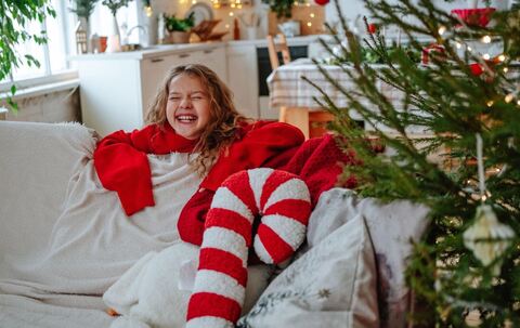 Mädchen lacht voller Vorfreude während der Weihnachtszeit