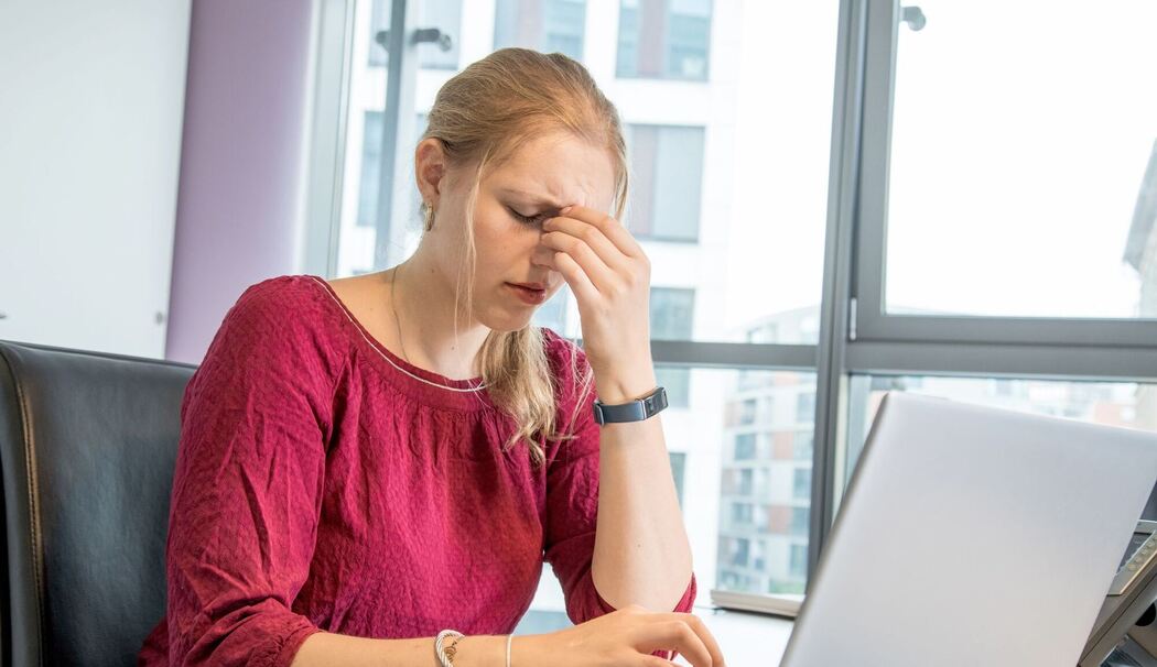 Eine Frau reibt sich die Augen am Arbeitsplatz Eine Frau reibt sich die Augen am Arbeitsplatz