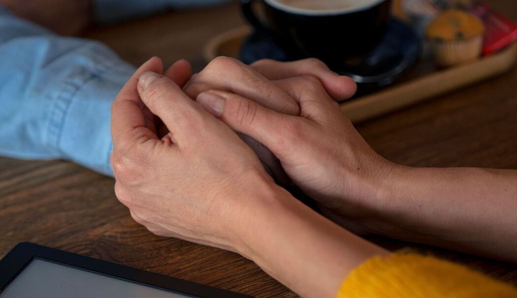 Zwei Personen halten sich an den Händen